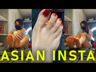 cute asian girl shows her paws with red pedicure